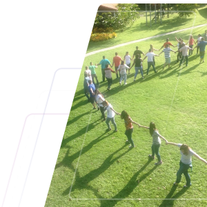 Foto de evento TEAL realizado pela duodot. Na foto uma pequena parte de um enorme espiral de pessoas de mãos dadas em atividade ao ar livre, lindo gramado com trilha ao fundo em dia ensolarado